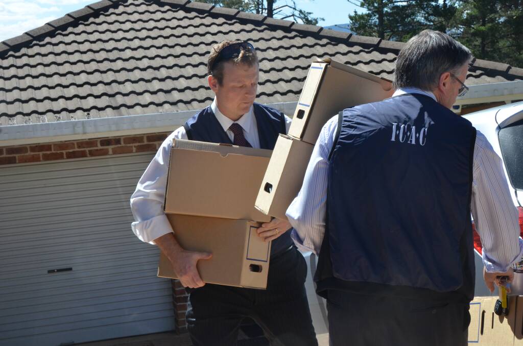 BOXES OF DOCUMENTS: ICAC officers place boxes full of documents in their.
